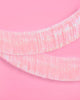 Light pink foil fringe banner hung as a party backdrop