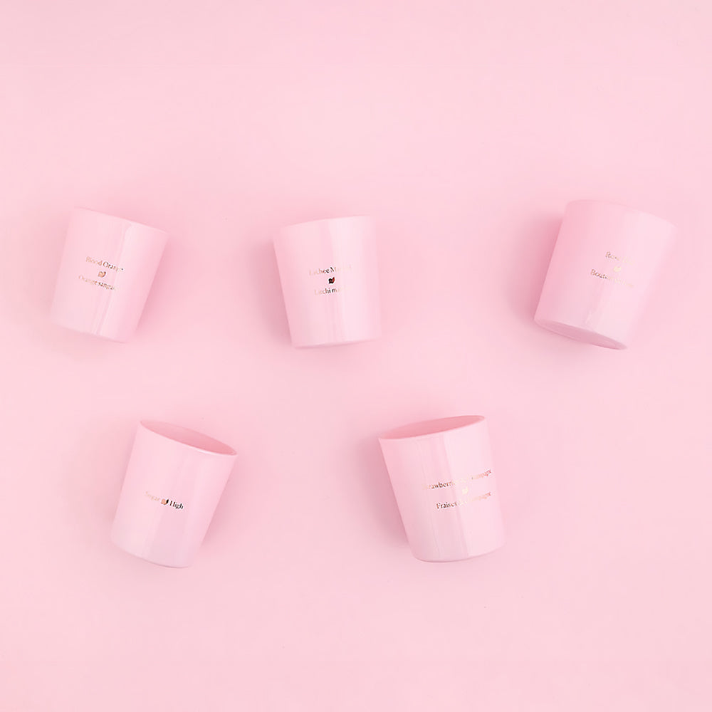 Five HighOnLove mini massage candles on a pink background