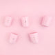 Five HighOnLove mini massage candles on a pink background