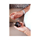 Hands holding the uncapped Black Diamond bottle and its clear cap, overhead view