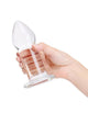 Clear glass anal dilator, held in hand