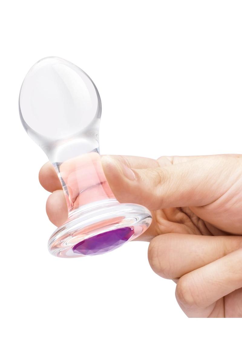 Clear glass butt plug, held in hand