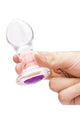 Clear glass butt plug, held in hand