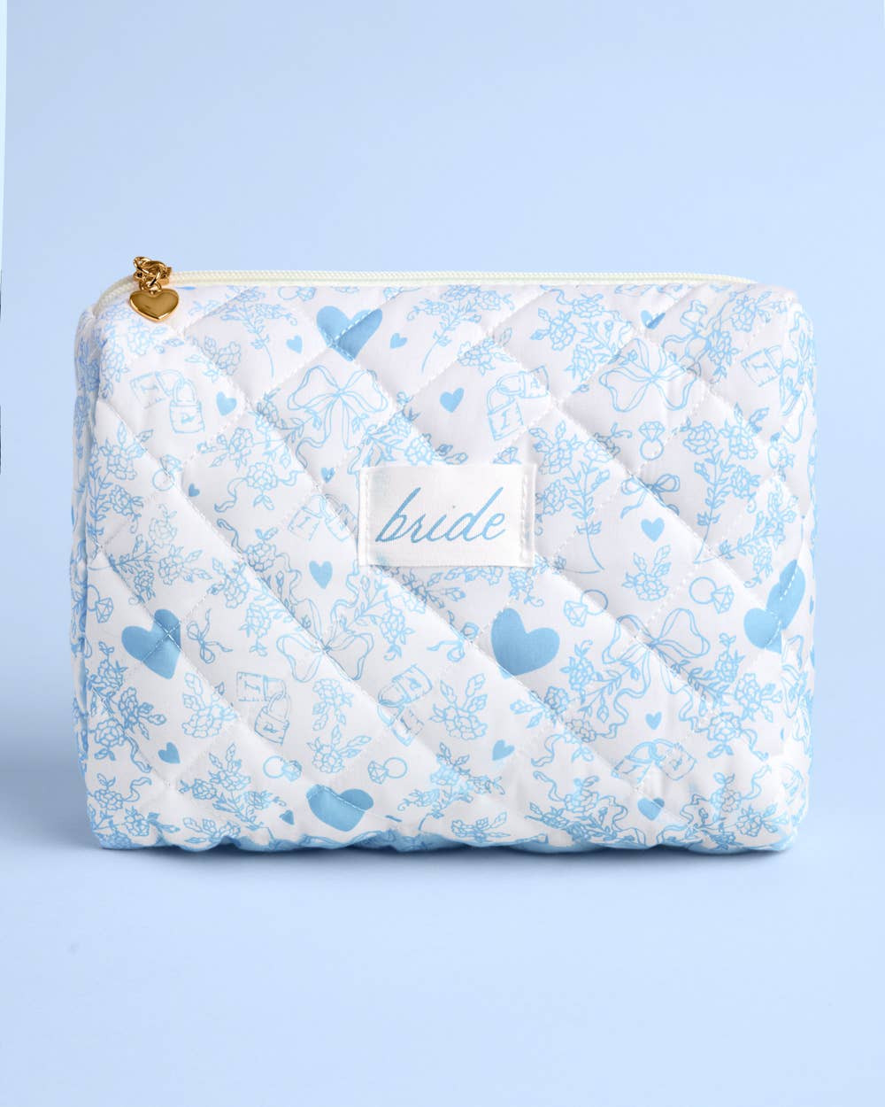 White diamond quilted cosmetic bag with blue floral print and gold heart zipper