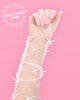 Sheer white organza glove on the hand with satin bows