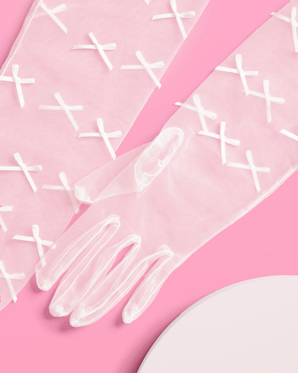 Detail of sheer white glove fingers and bow trim