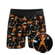 Black boxer brief with an orange dancing reindeer print, front view with print detail inset