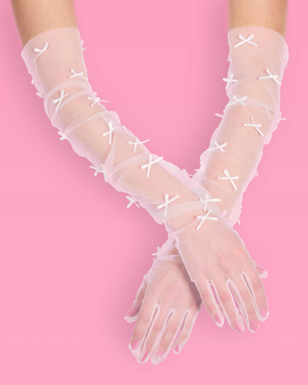 Pair of sheer white bow opera gloves crossed at the wrist